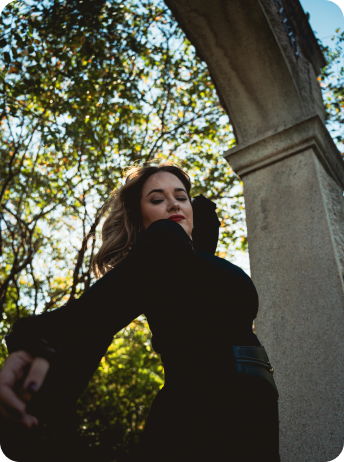 Layla Kara outdoors, looking up through trees.